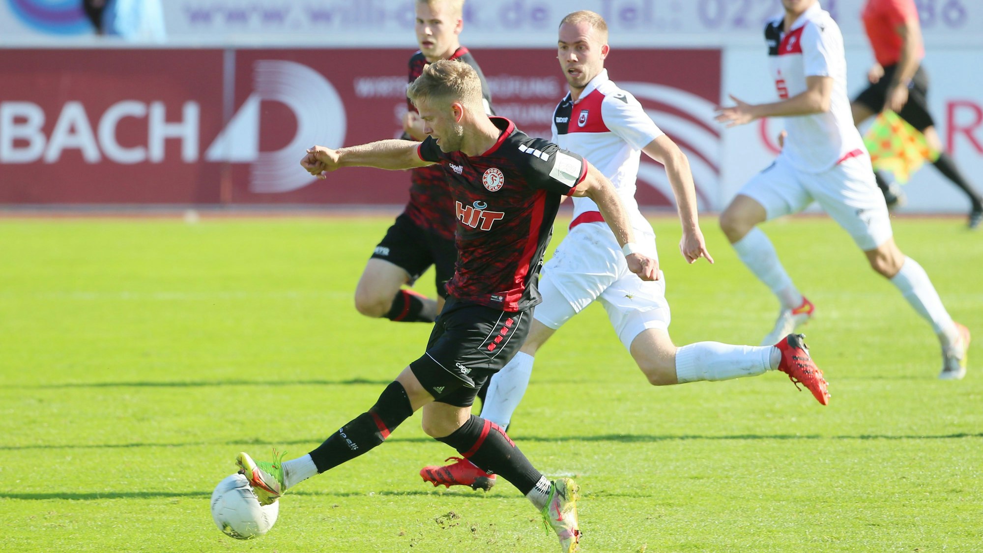 Ein Fußballspieler schießt den Ball mit dem linken Fuß Richtung Tor.