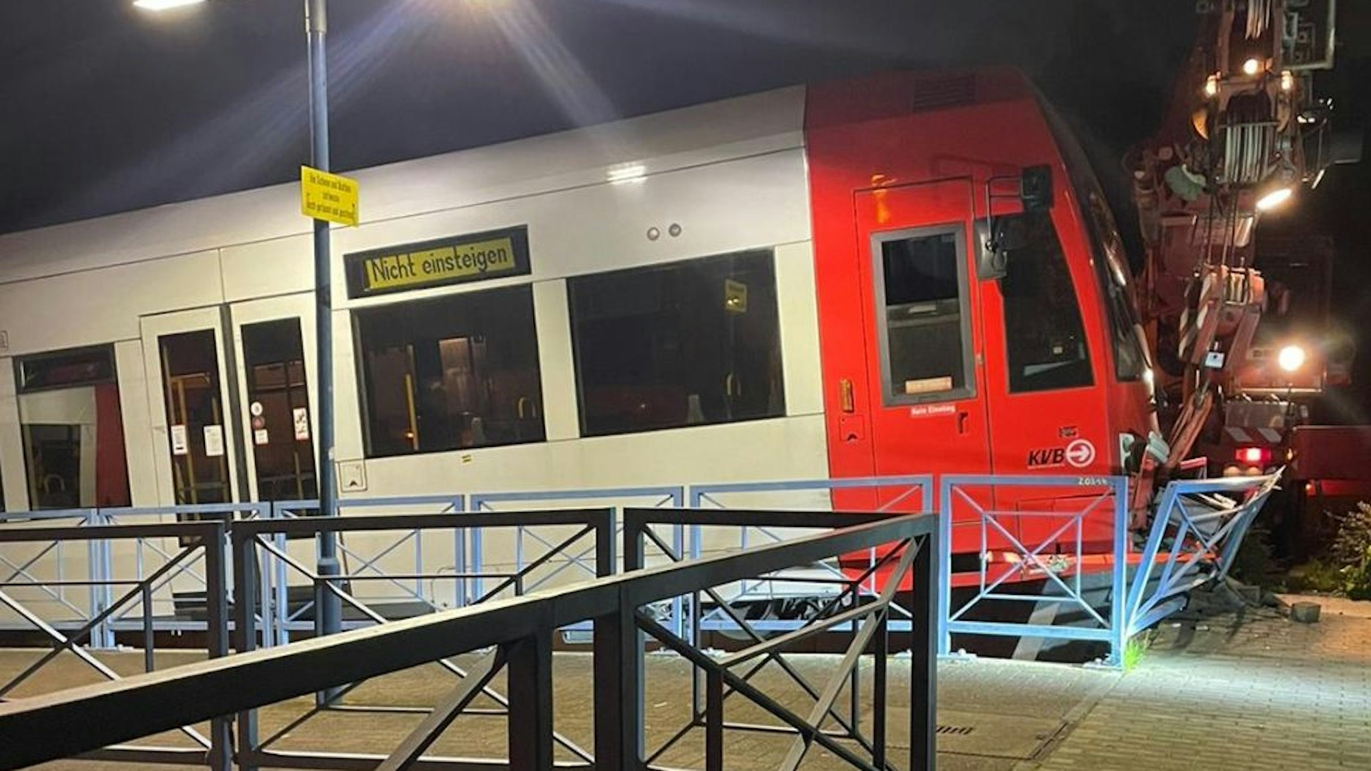 Eine Straßenbahn, die an einer Endhaltestelle gegen den Prellbock gefahren ist und die Bahnsteigbegrenzung durchbricht.