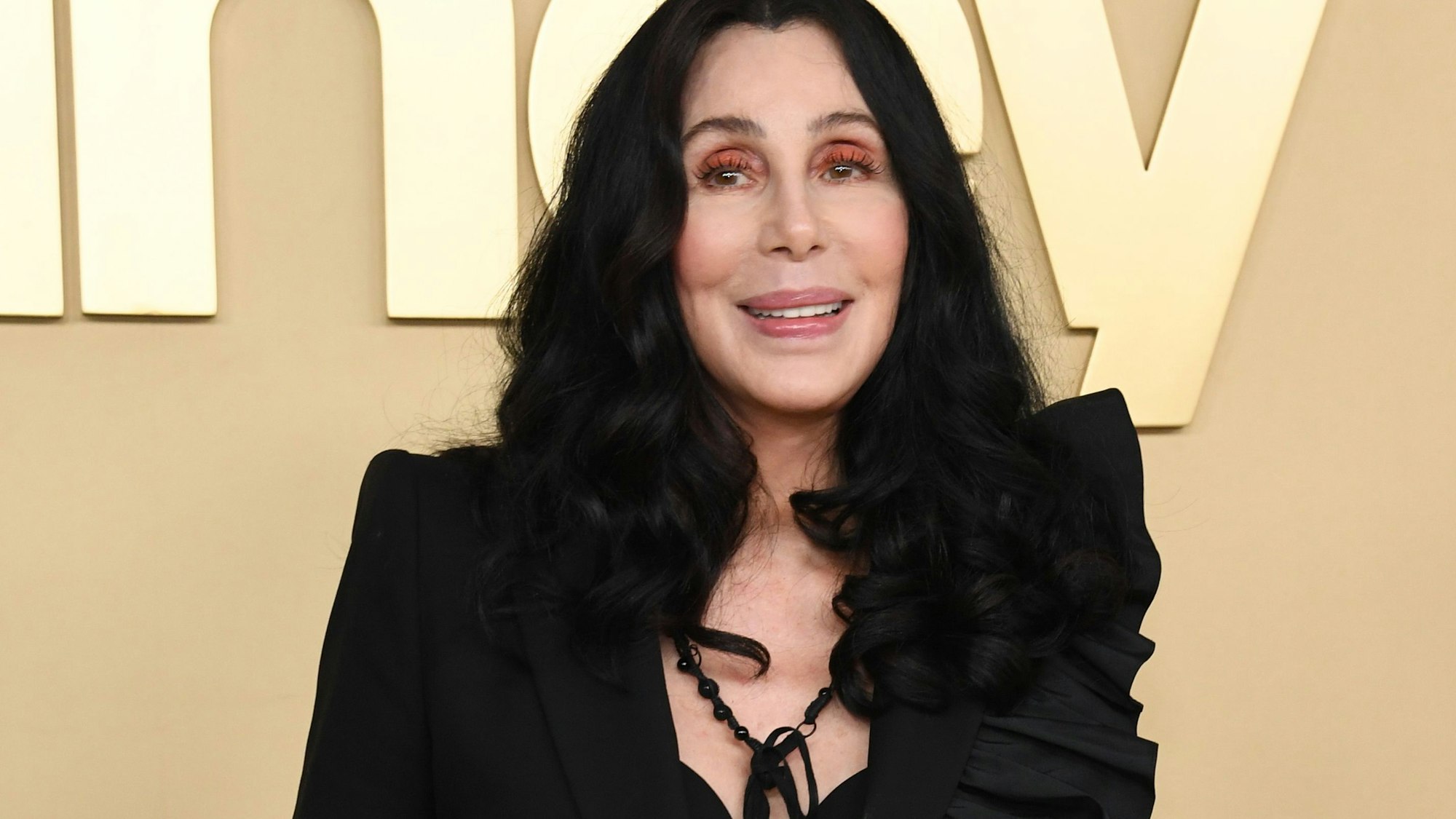 Cher lächelt in die Kamera.