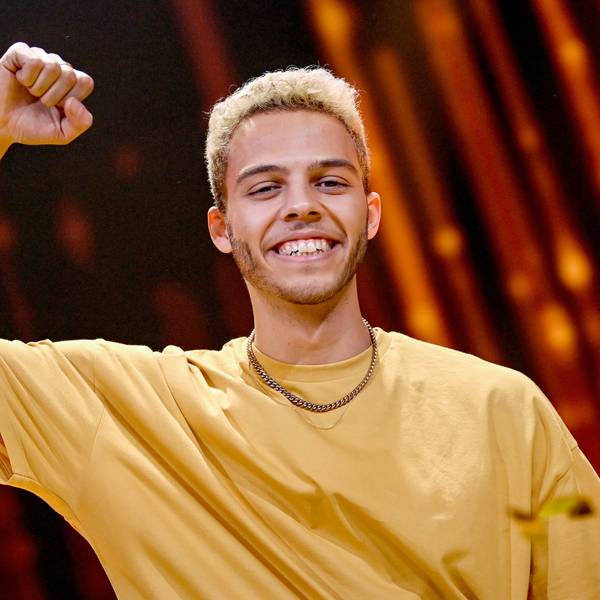 Malik Harris freut sich bei der Show „Germany 12 Points - der deutsche ESC-Vorentscheid“ über den Sieg. Er ballt die Faust und streckt den Arm nach oben. Er trägt eine Goldkette und ein gelbes T-Shirt.
