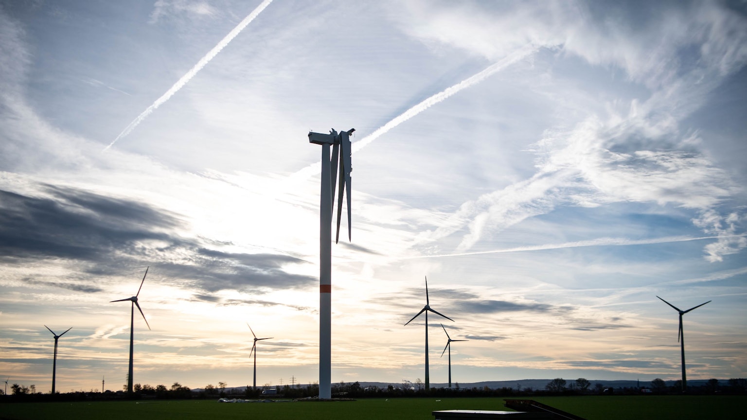 Auf einem Feld bei Zülpich stehen sieben Windräder. Bei dem vordersten fehlt ein Flügel, ein zweiter hängt nur noch in Teilen am Korpus.