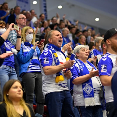 Zuschauern in der Schwalbe-Arena feiern in Trickots vom Vfl Gummersbach ihre Mannschaft an.