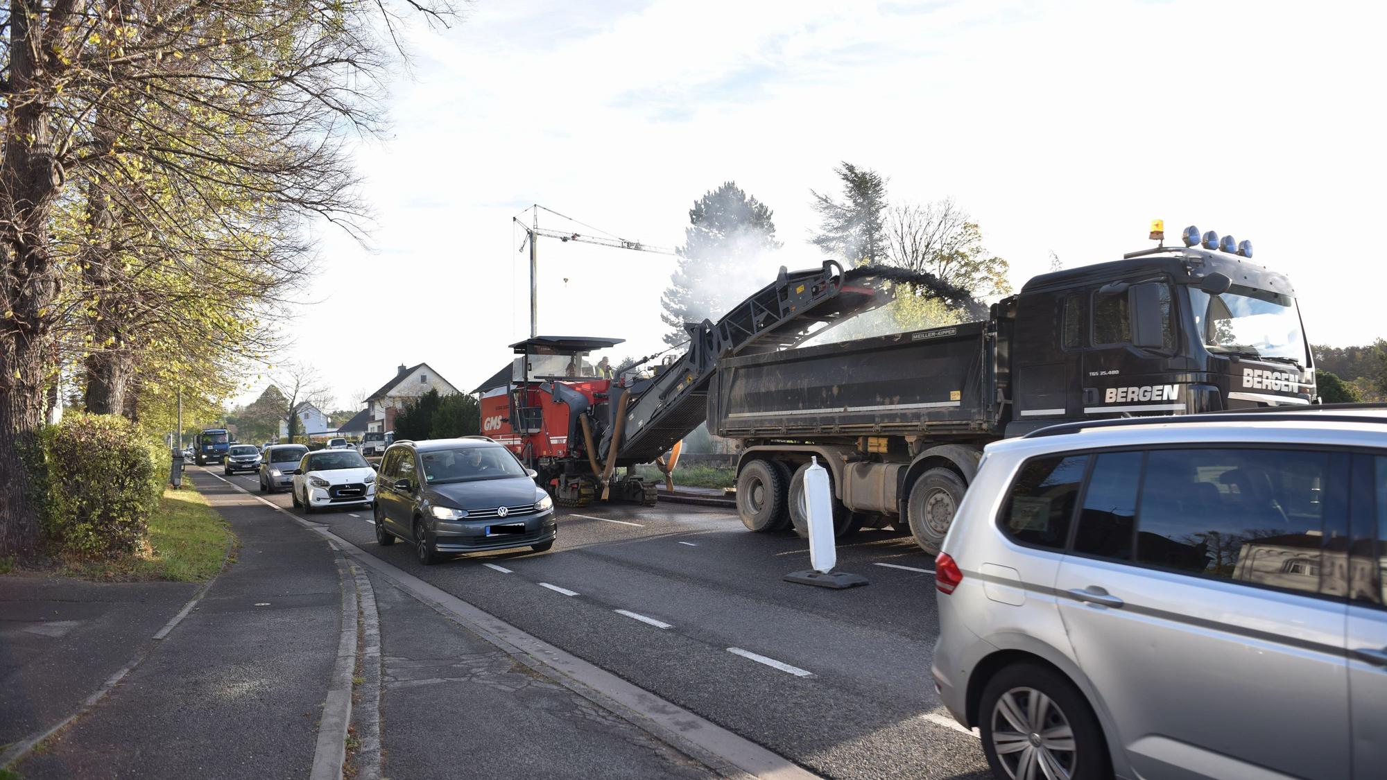Viele Autos fahren dicht an den Baustellenfahrzeugen auf der B266 vorbei.