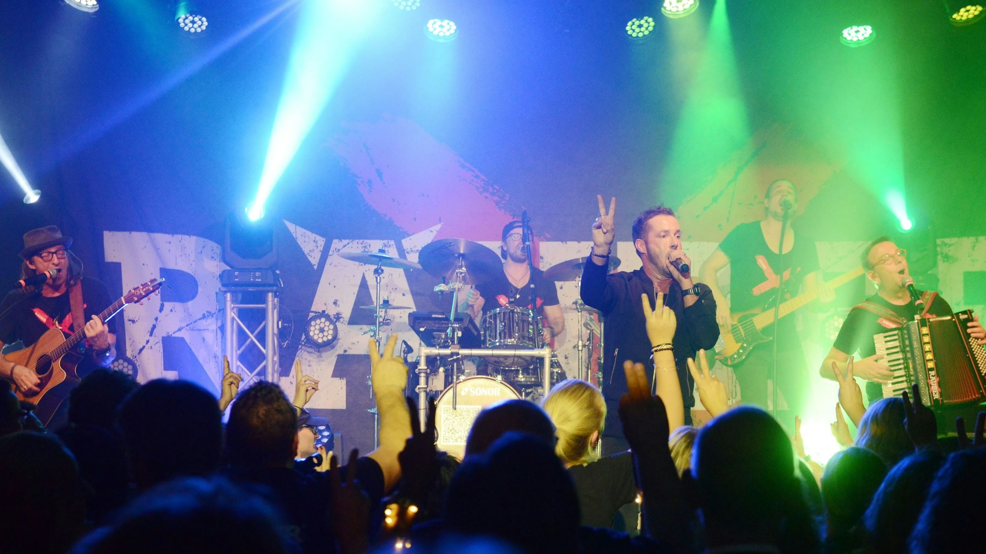 Die Räuber auf der Bühne im Club Volta in Mülheim mit Publikum im Vordergrund.