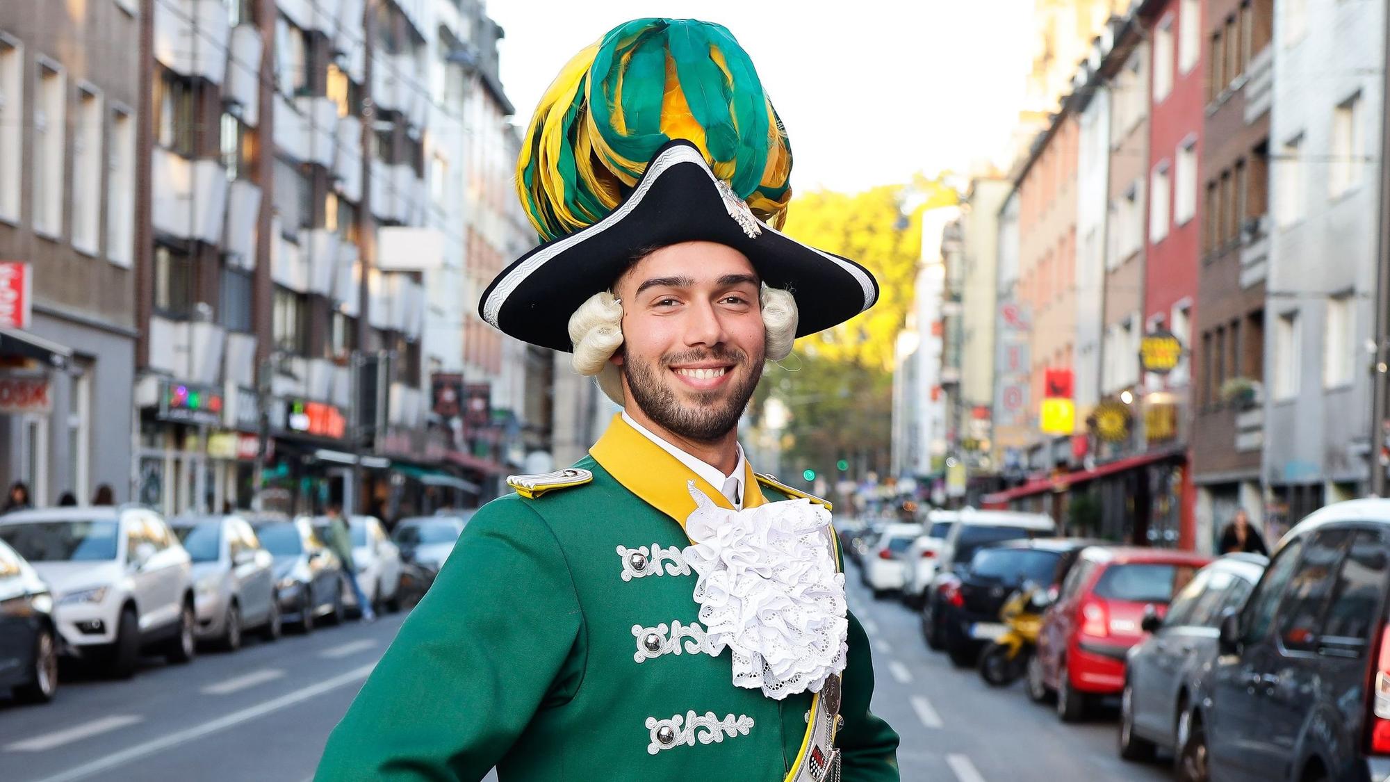 Davide Giangualano in der grün-gelben Unifor der Kölner Karnevalsgesellschaft "Ehrengarde" auf der Zülpicher Strasse.
