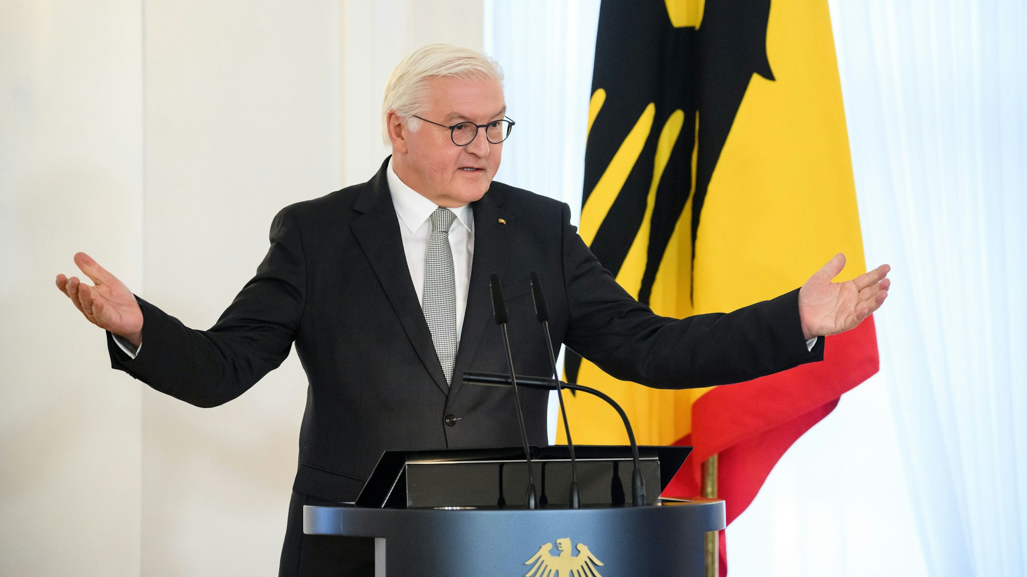 Bundespräsident Frank-Walter Steinmeier breitet bei seiner Eröffnungsrede der Tagung·„Wie erinnern wir den 9. November?“ die Arme aus.