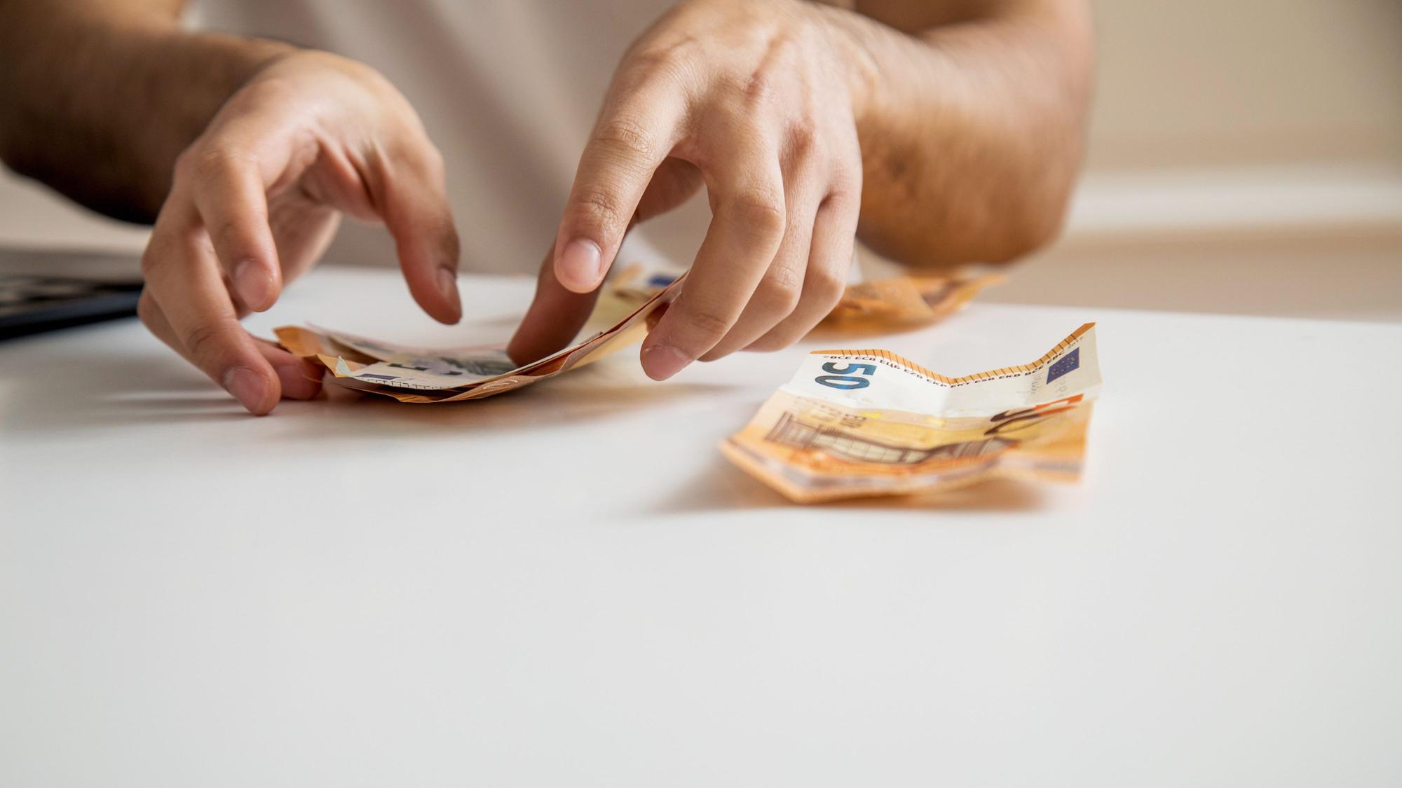 Hände sortieren 50-Euro-Scheine