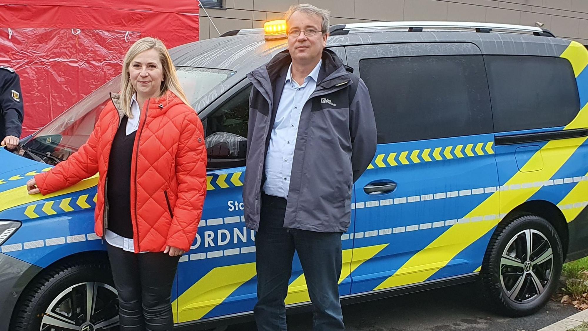 Bürgermeisterin Susanne Stupp und Ordnungsdezernent Patrick Lehmann stehen vor einem Einsatzfahrzeug des Frechener Ordnungsamts.