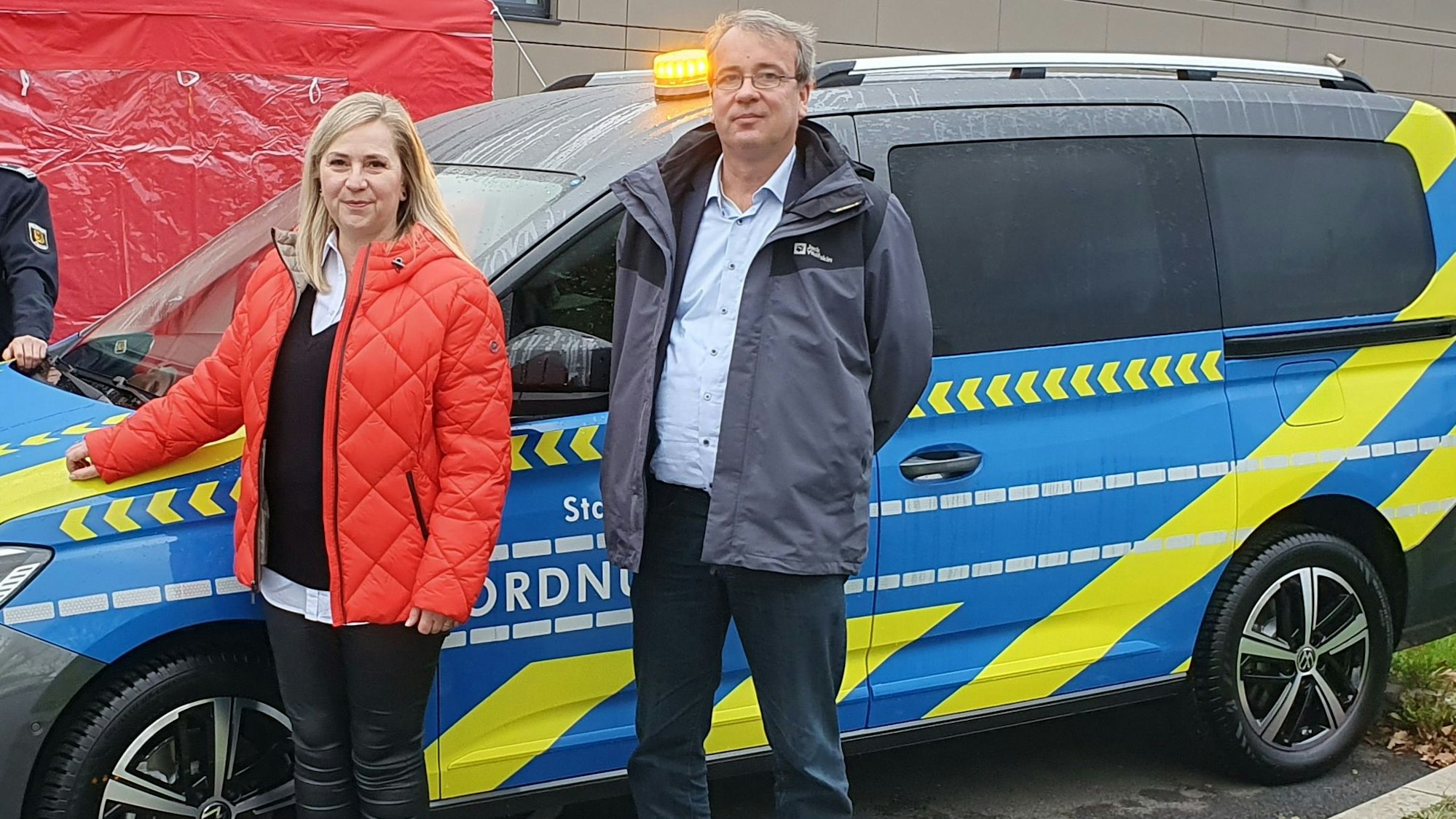 Bürgermeisterin Susanne Stupp und Ordnungsdezernent Patrick Lehmann stehen vor einem Einsatzfahrzeug des Frechener Ordnungsamts.