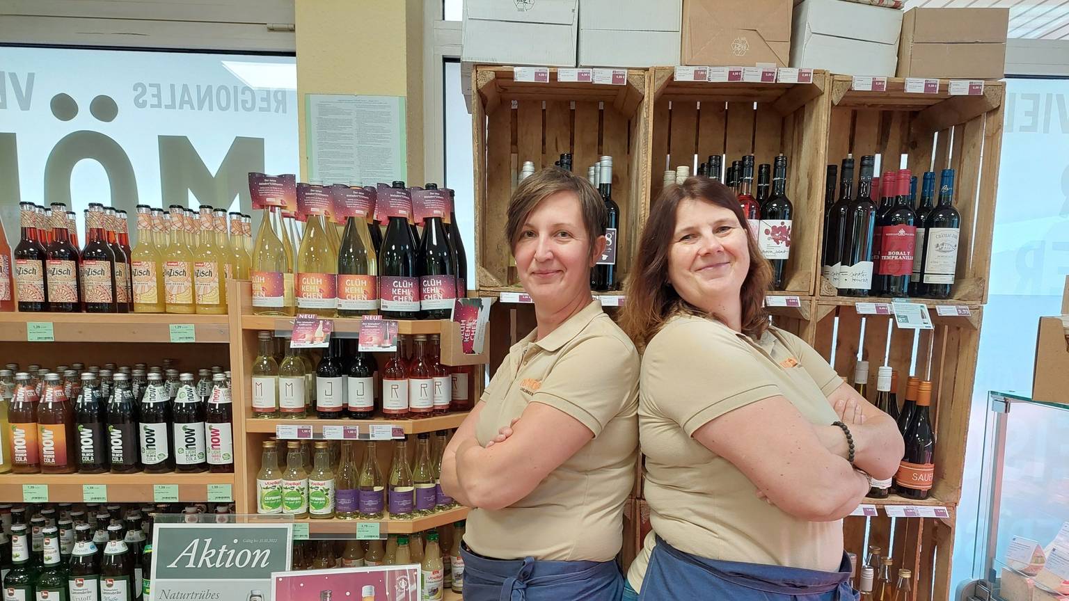 Saskia und Ulrike Effey stehen vor einem Regal voller Bio-Weine und Säfte.