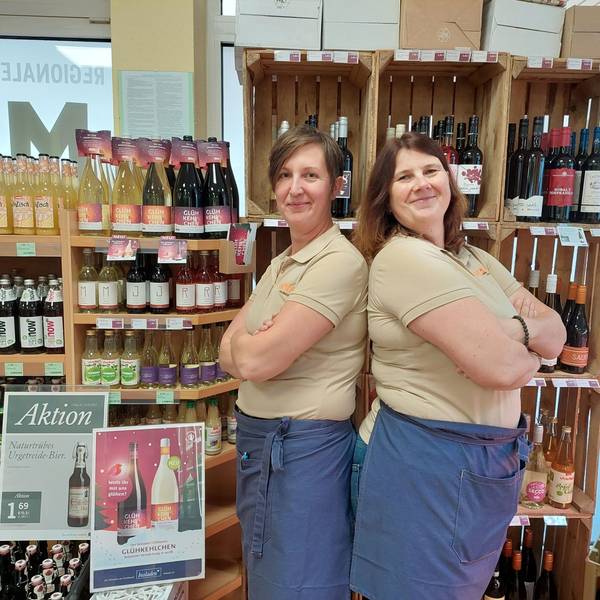 Saskia und Ulrike Effey stehen vor einem Regal voller Bio-Weine und Säfte.