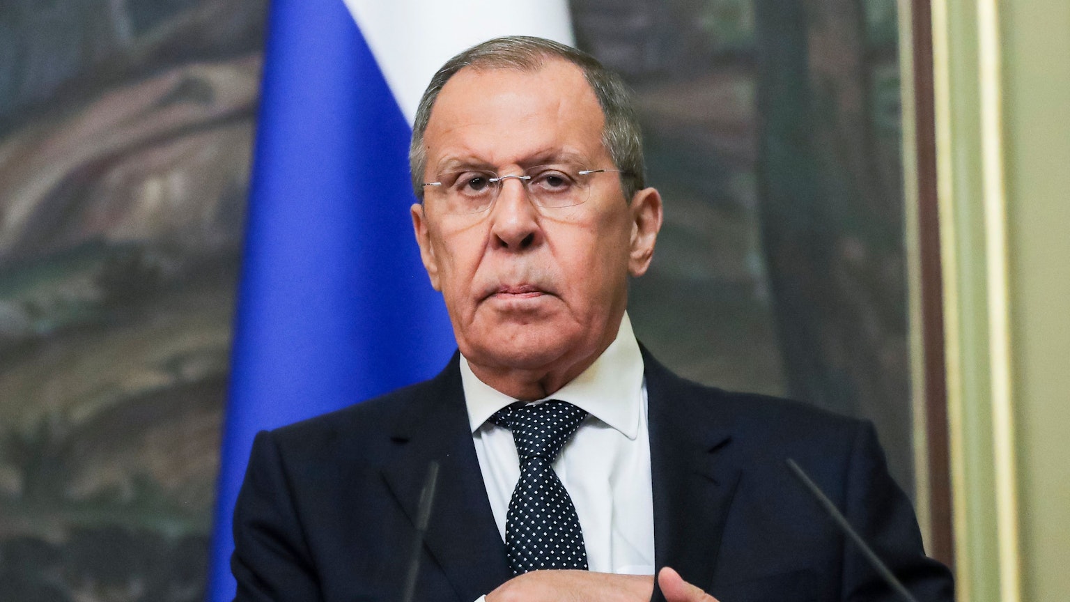 Der russische Außenminister Sergej Lawrow greift sich in die Innentasche des Jacketts und schaut in die Kamera.