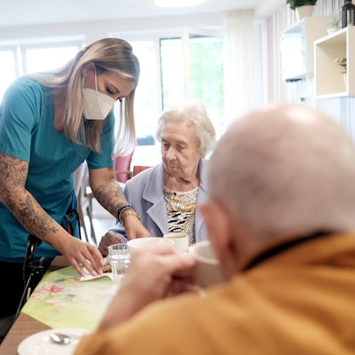 Im Caritas-Zentrum St. Maternus in Rodenkirchen kümmert sich eine Pflegerin um zwei Heimbewohner.