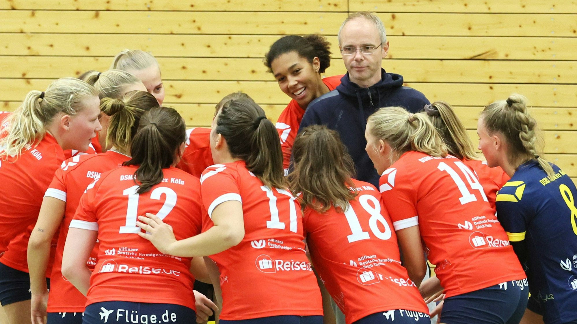 Ein Volleyballtrainer steht während einer Auszeit im Kreise seines Teams.