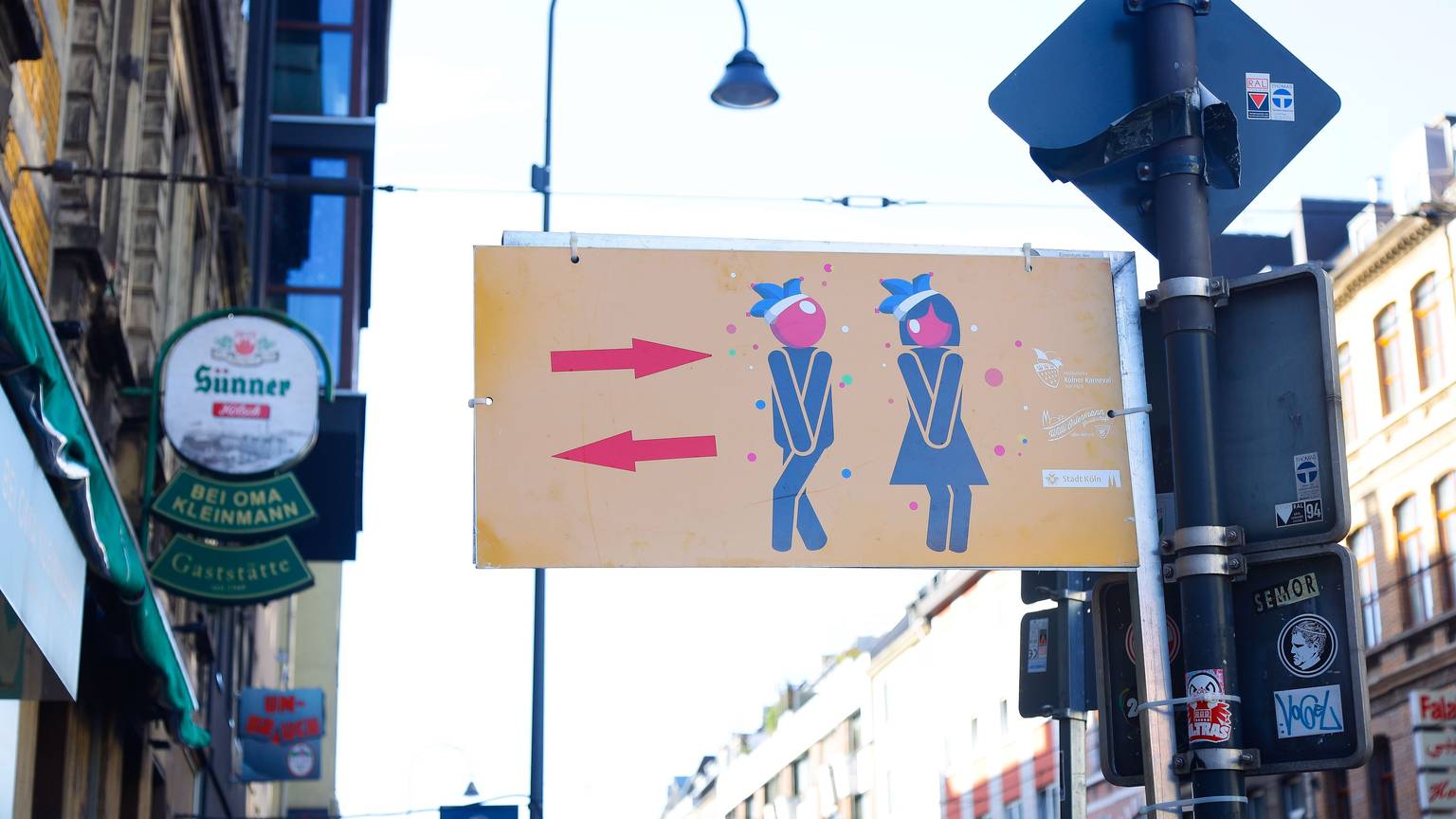Das Bild zeiht ein Hinweisschild für die Toiletten auf der Zülpicher Straße an Karneval.
