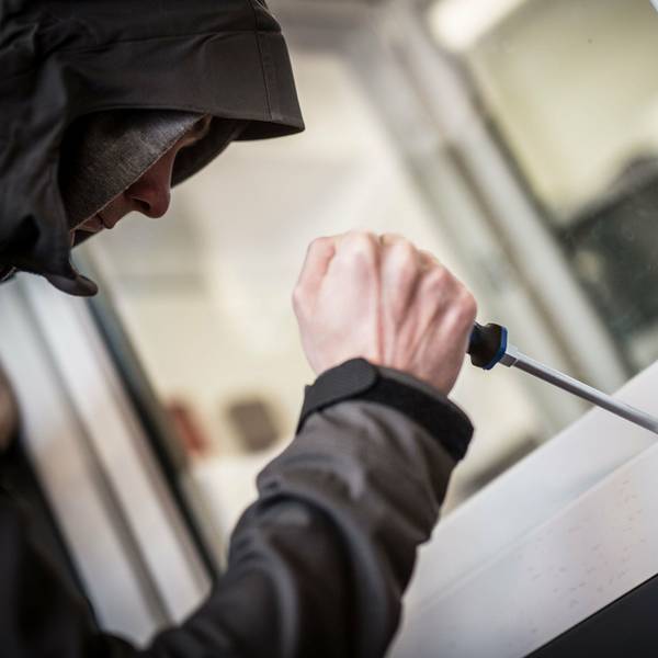 Ein Mann mit einem Werkzeug an einem Fenster.