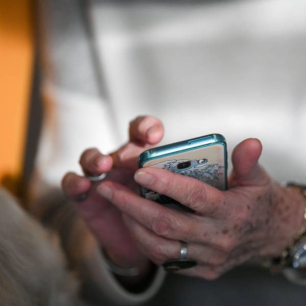 Eine Seniorin hält ihr Smartphone in den Händen.