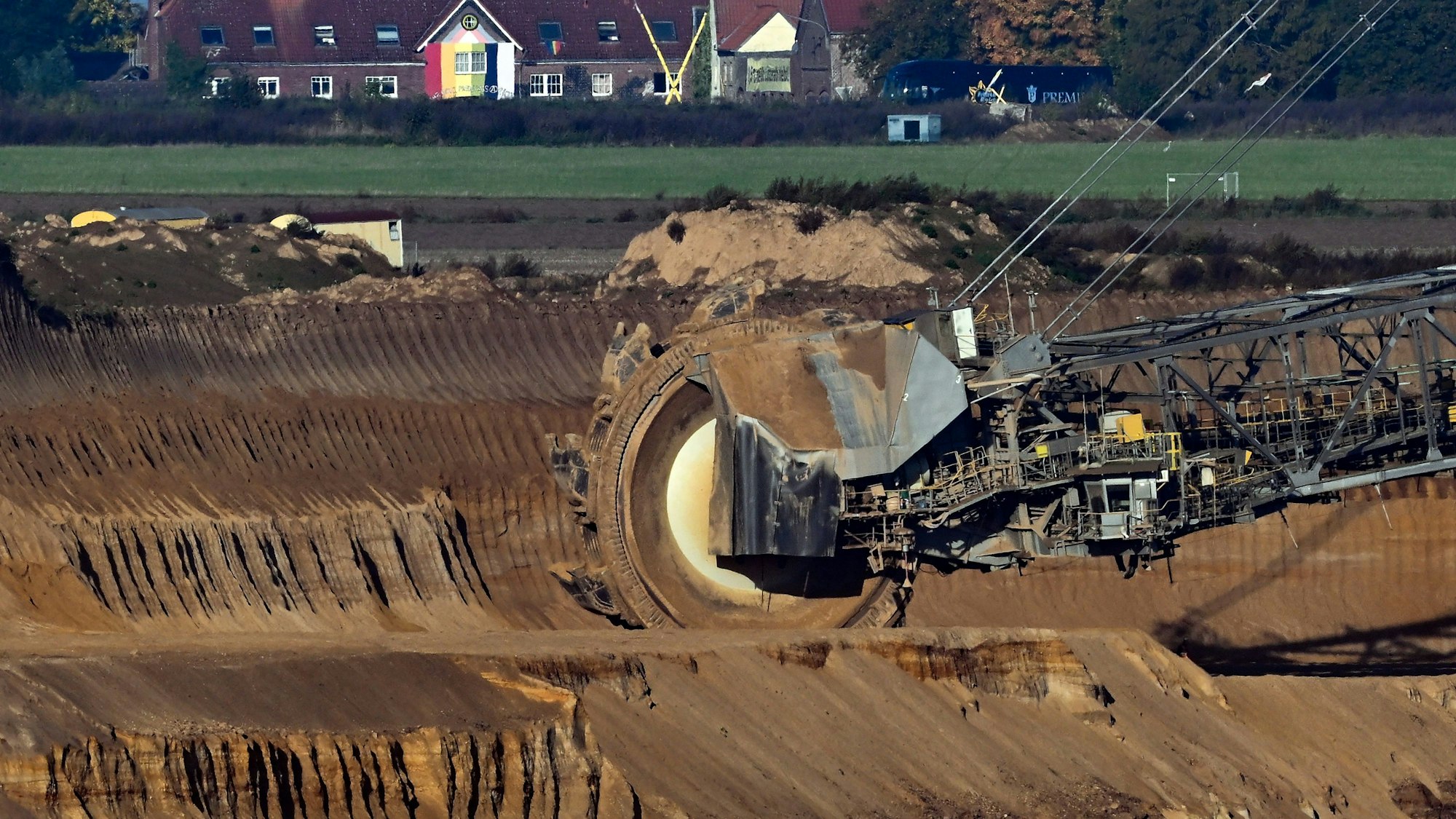 Nordrhein-Westfalen, Jüchen: Ein Schaufelradbagger arbeitet im Braunkohletagebau Garzweiler. Im Hintergrund ist die Ortschaft Lützerath zu sehen.