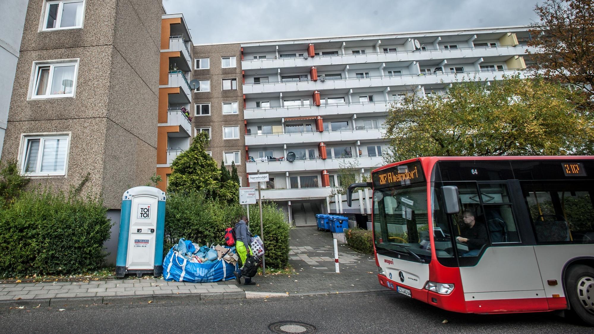 Blick auf ein Mehrfamilienhaus mit Dutzenden Balkonen. Davor verläuft die Fichtestraße, ein Bus fährt gerade an dem Gebäude vorbei.