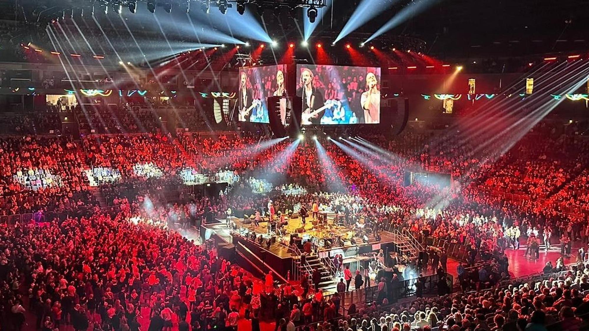 Blick auf den Innenraum in der Arena mit der Bühne in der Mitte, auf der die Band Cat Ballou steht.