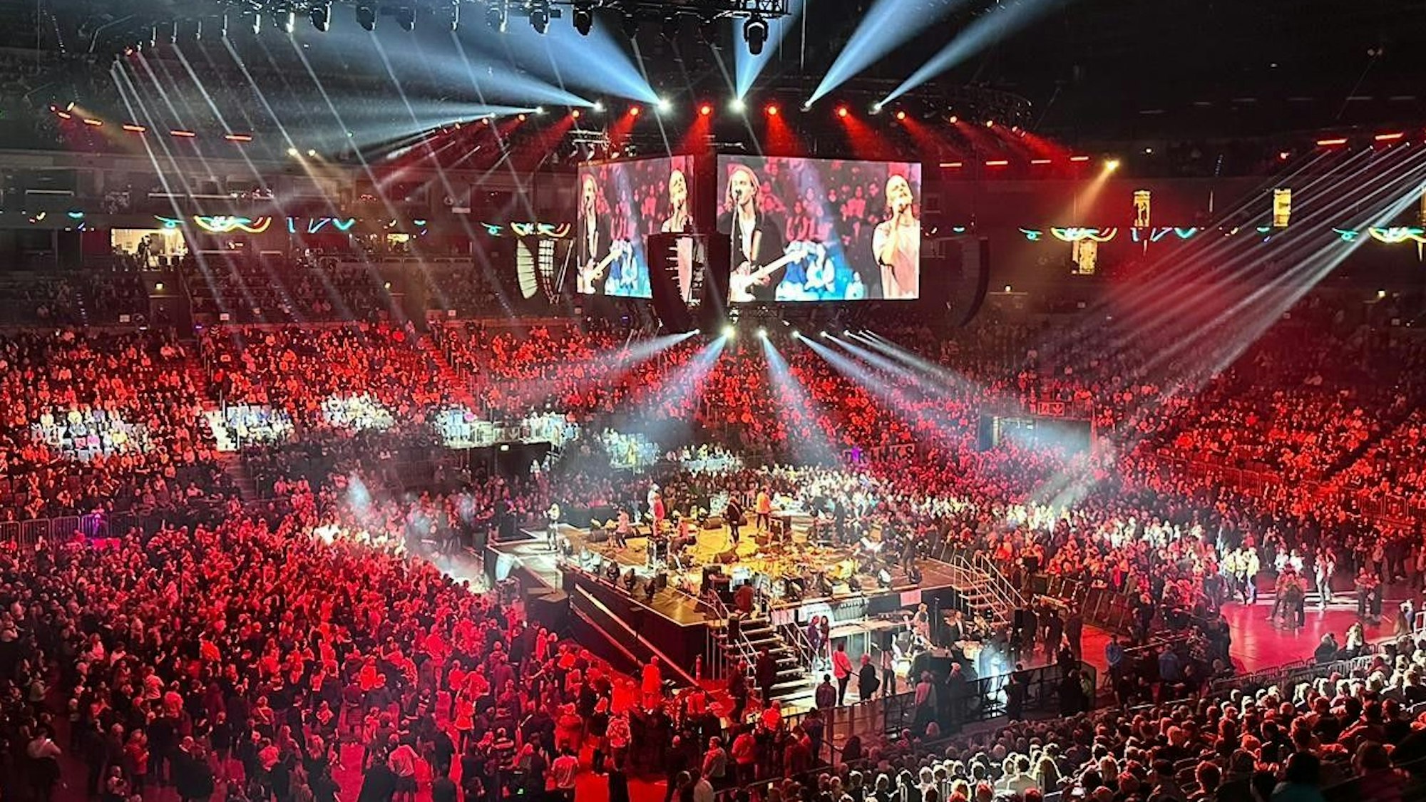 Blick auf den Innenraum in der Arena mit der Bühne in der Mitte, auf der die Band Cat Ballou steht.
