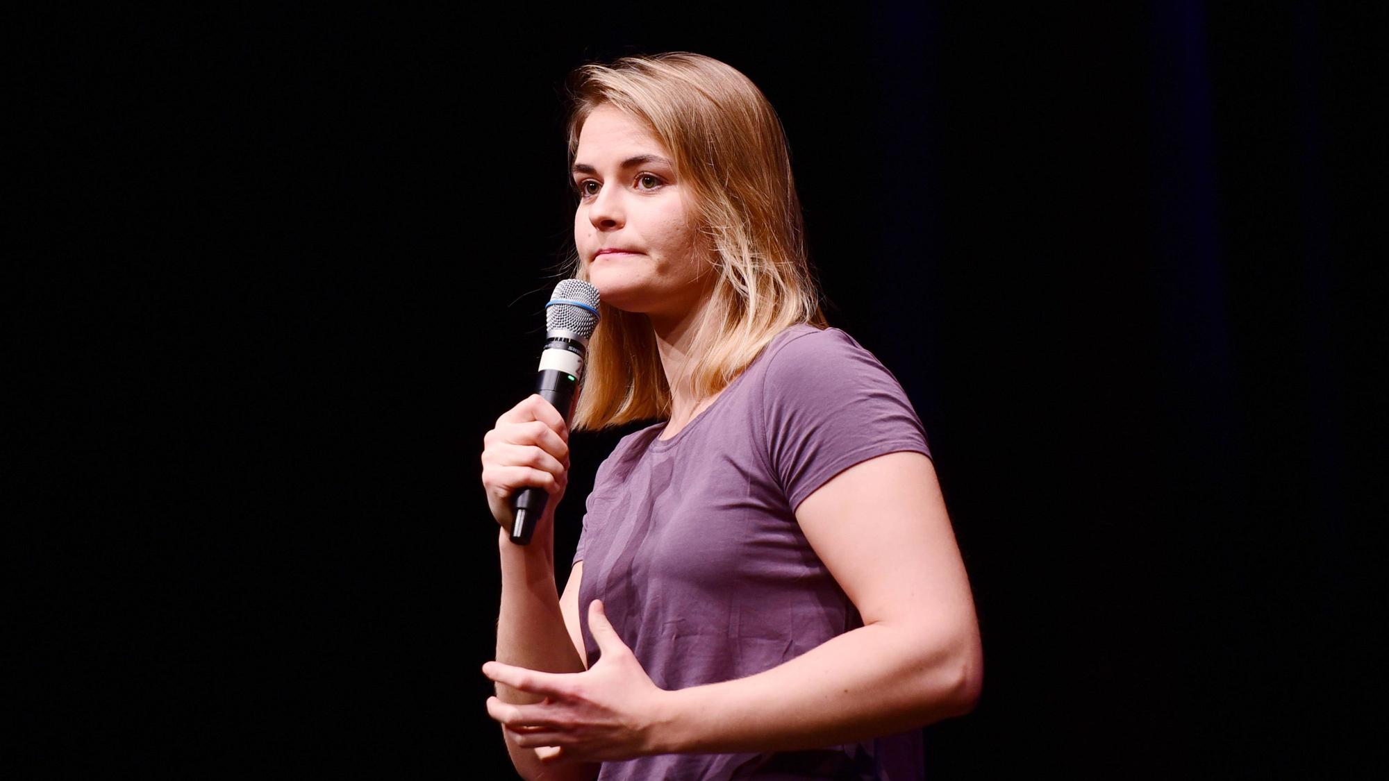 Hazel Brugger steht bei einer Show auf der Bühne und schaut ins Publikum.