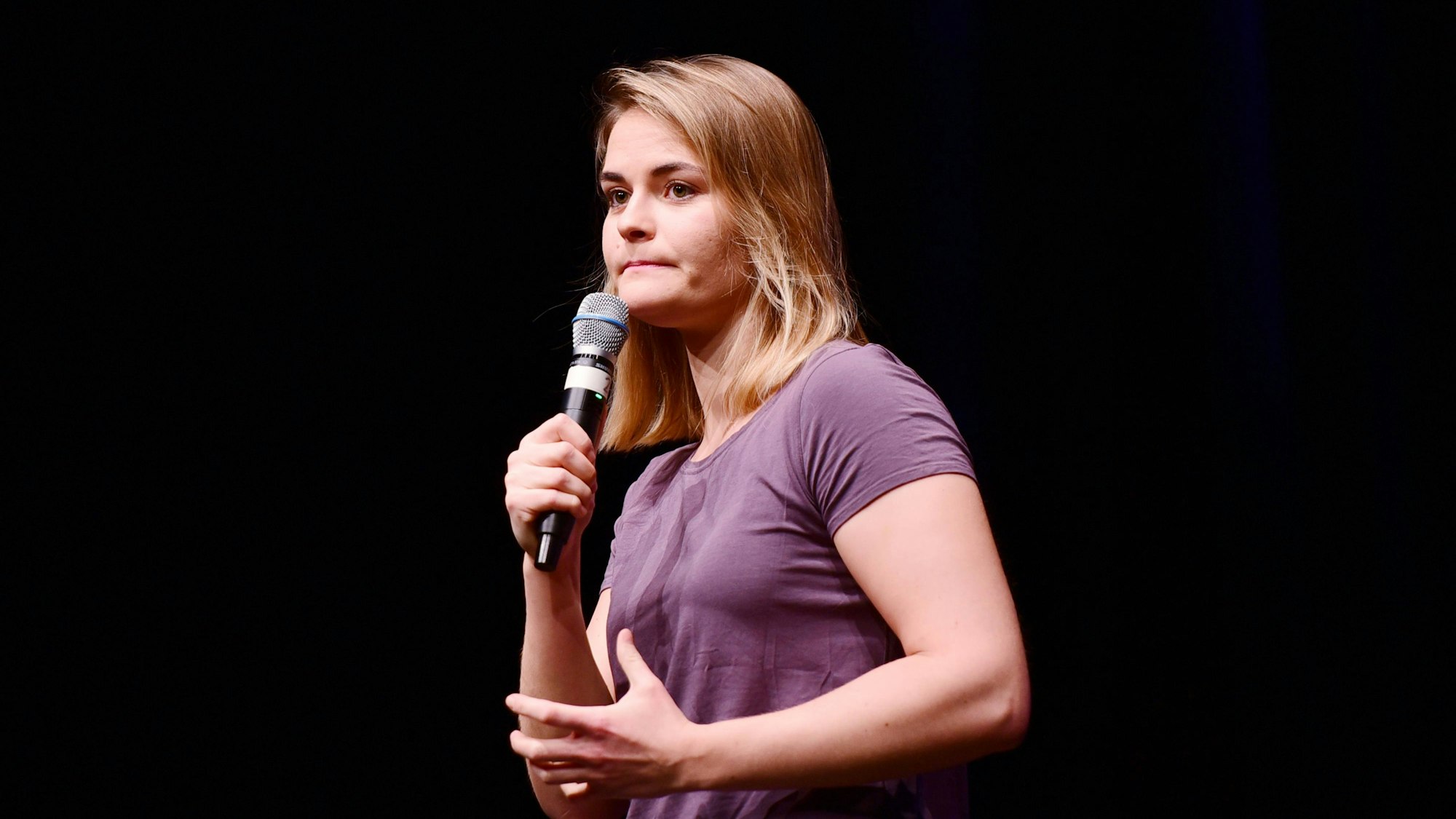 Hazel Brugger steht bei einer Show auf der Bühne und schaut ins Publikum.