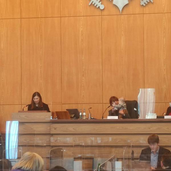 Jennifer Glashagen spricht im Ratssaal, Henriette Reker sitzt daneben mit Glashagens Baby