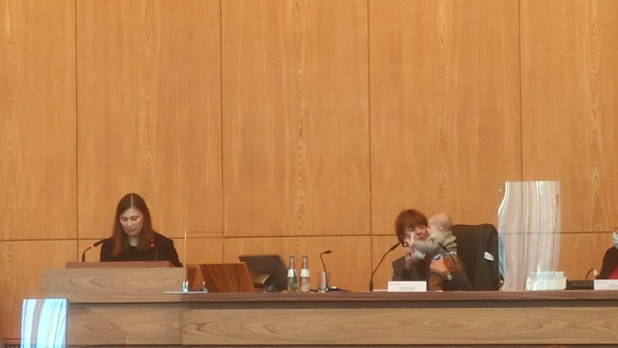 Jennifer Glashagen spricht im Ratssaal, Henriette Reker sitzt daneben mit Glashagens Baby