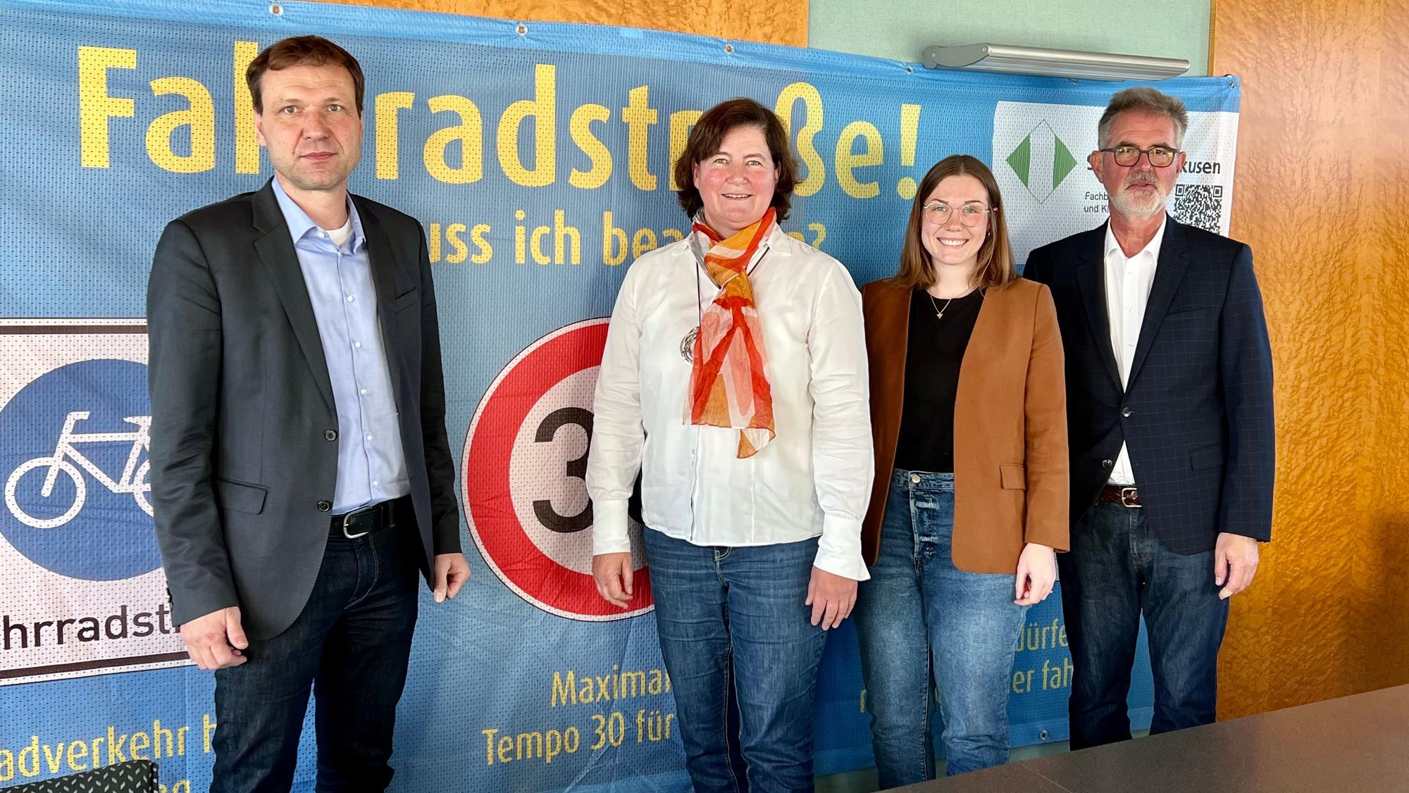 Umweltdezernent Alexander Lünenbach, Fachbereichsleiterin Christiane Jäger, Klimaschutzmanagerin Stefanie Bergmann und Mobilitätsmanager Christian Syring vor einem Banner, das für Fahrradstraßen wirbt