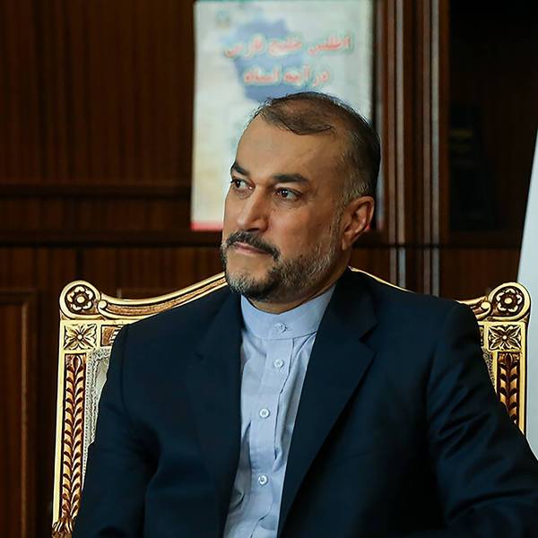 Hossein Amir-Abdollahian, iranischer Außenminister, sitzt auf einem goldenen Stuhl, im Hintergrund ist eine iranische Fahne zu sehen.