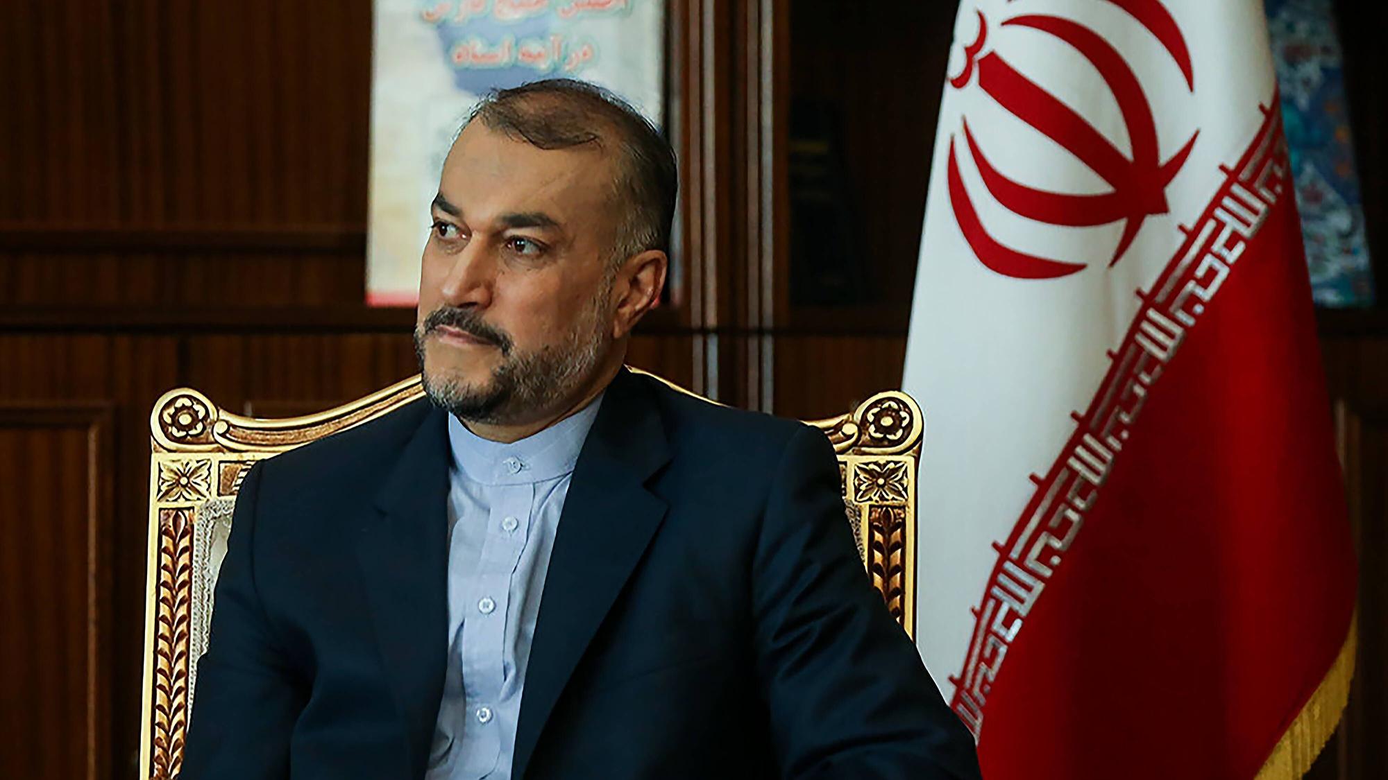 Hossein Amir-Abdollahian, iranischer Außenminister, sitzt auf einem goldenen Stuhl, im Hintergrund ist eine iranische Fahne zu sehen.