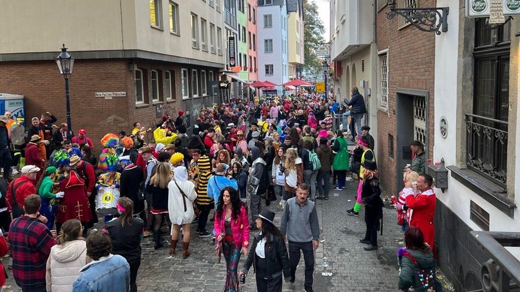 Enge Gasse in der Altstadt Köln. Viele Menschen feiern Karneval in den Kneipen.