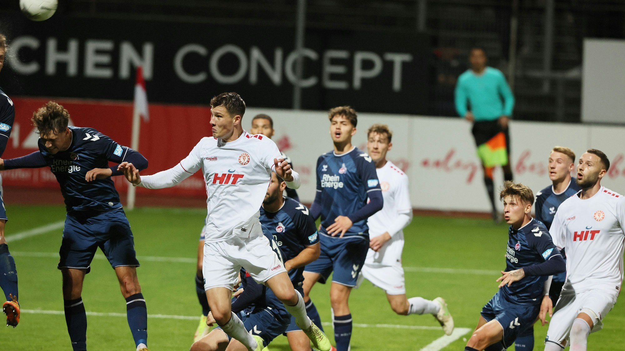Mehrere Fußballspieler springen hoch, um den Ball per Kopf zu erwischen.