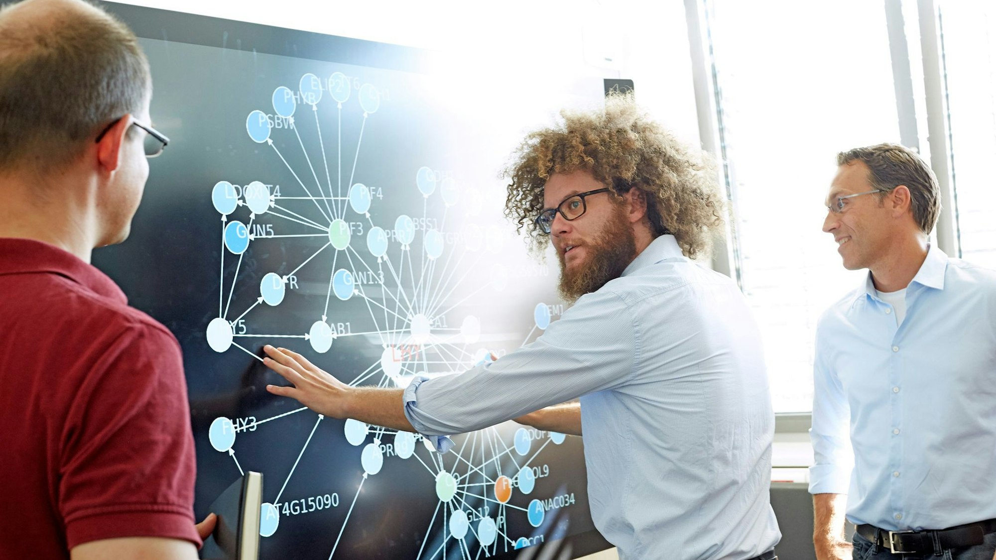 Dr. Sebastian Klie ist Chef des Biotech-Start-ups Targenomix. Hier steht er mit Kollegen an einer Tafel.