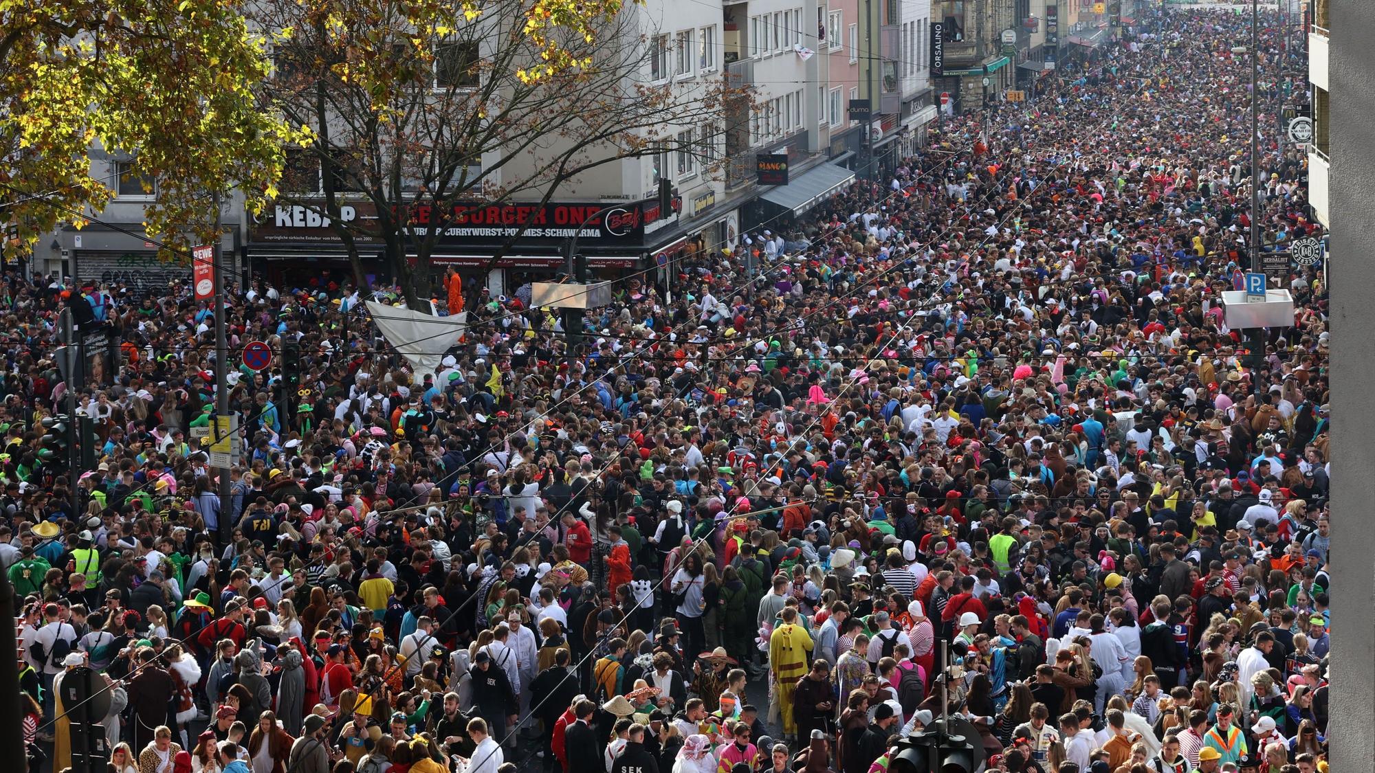 Dicht gedrängt stehen kostümierte Menschen am 11.11. auf der Zülpicher Straße zusammen.