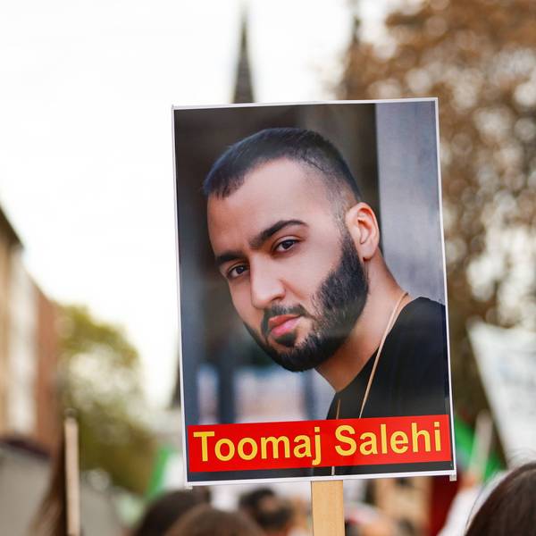 Ein Demonstrierender hält ein Schild mit dem Portrait des iranischen Rapper Toomaj Salehi bei einer Demonstration in Köln in die Höhe.