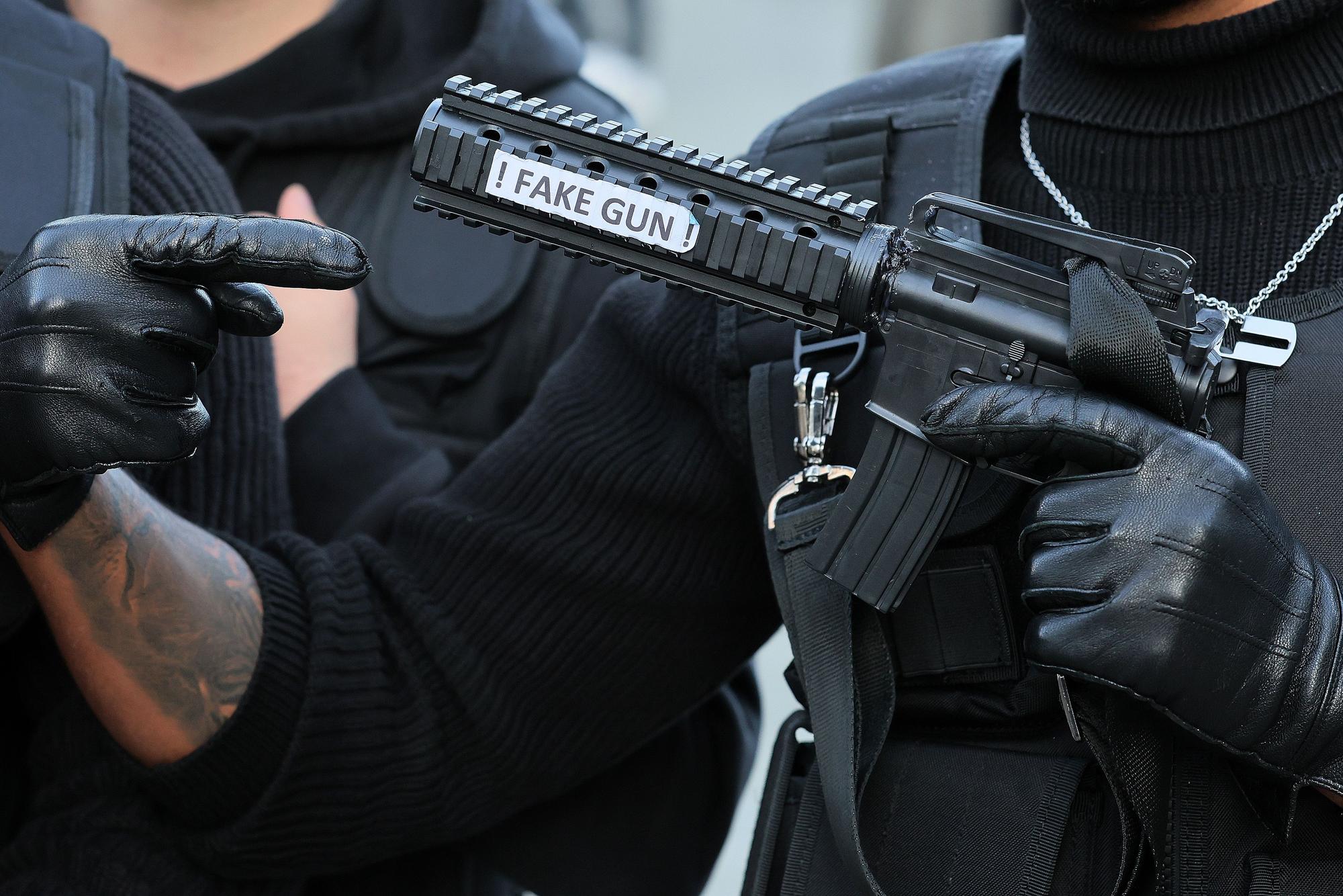 Auf einer Spielzeugwaffe steht „Fake Gun“.