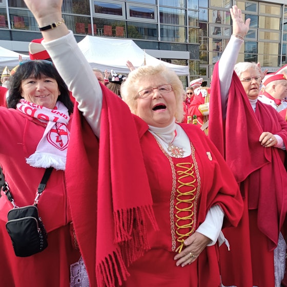 Karnevalistinnen jubeln und feiern in roter Kleidung den Sessionsauftakt in Bergheim.