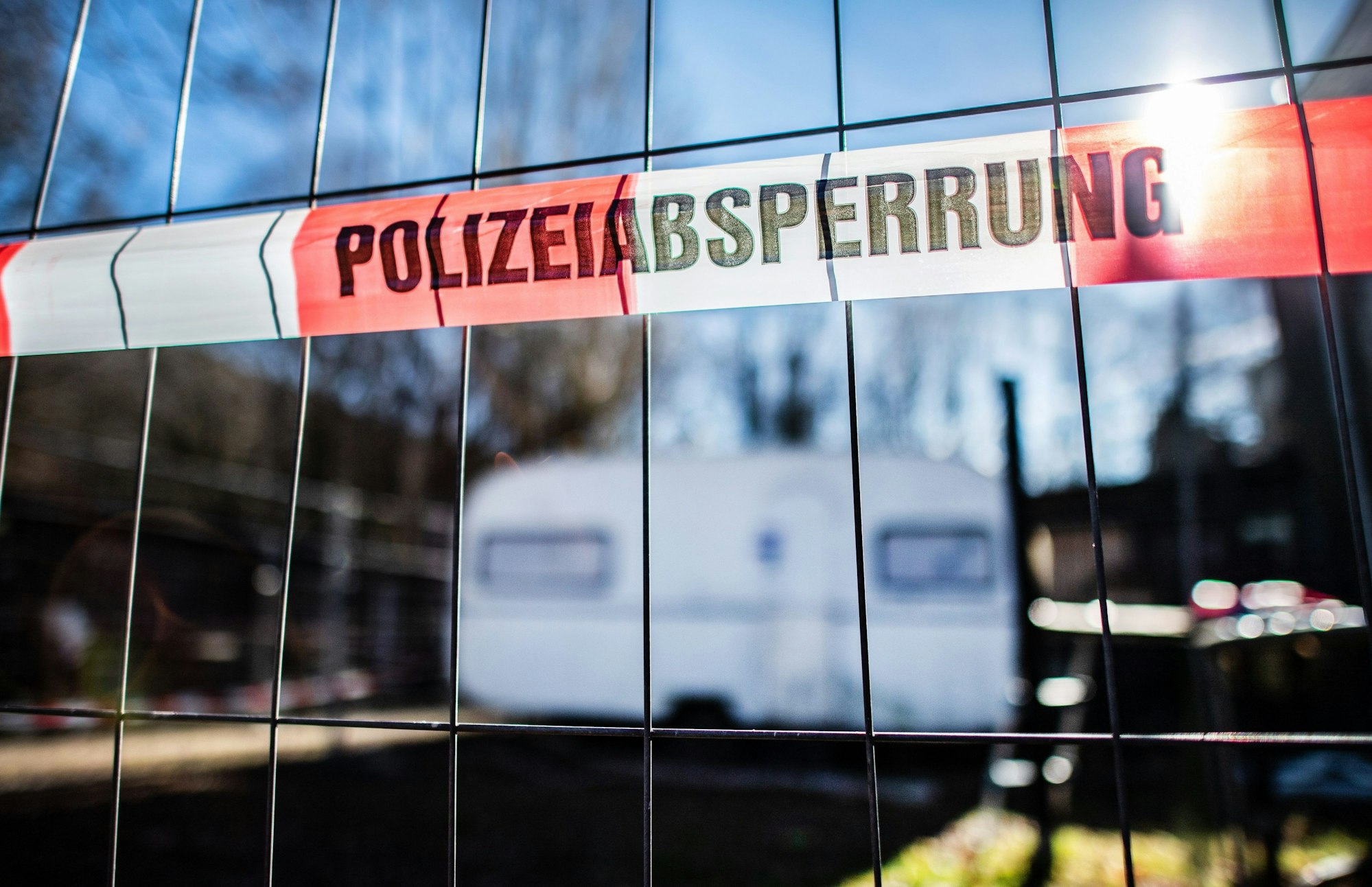 Auf dem Campingplatz Eichwald in Lügde hängt vor dem versiegelten Campingwagen eine Banderole mit der Aufschrift „Polizeiabsperrung" an einem Drahtzaun.