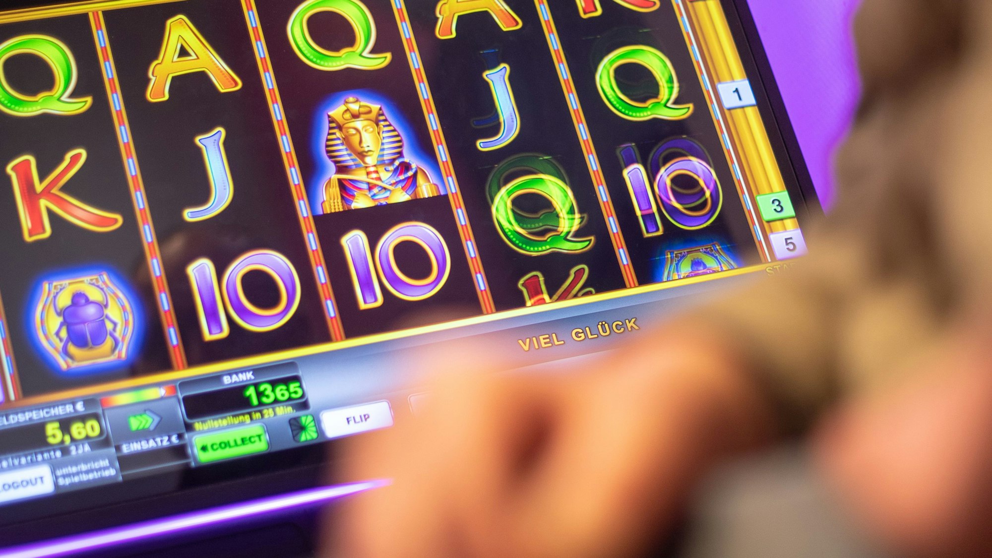 Ein Mann sitzt in einer Kneipe an einem Geldspielautomaten. Foto: Sebastian Gollnow/dpa