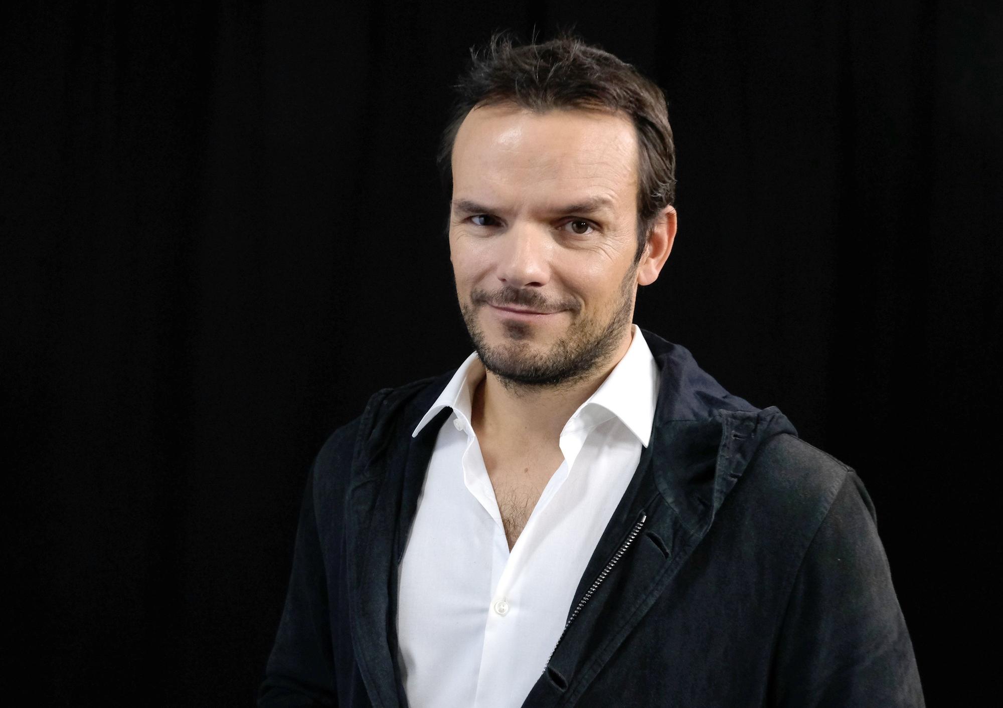 Starkoch Steffen Henssler vor einem schwarzen Hintergrund.