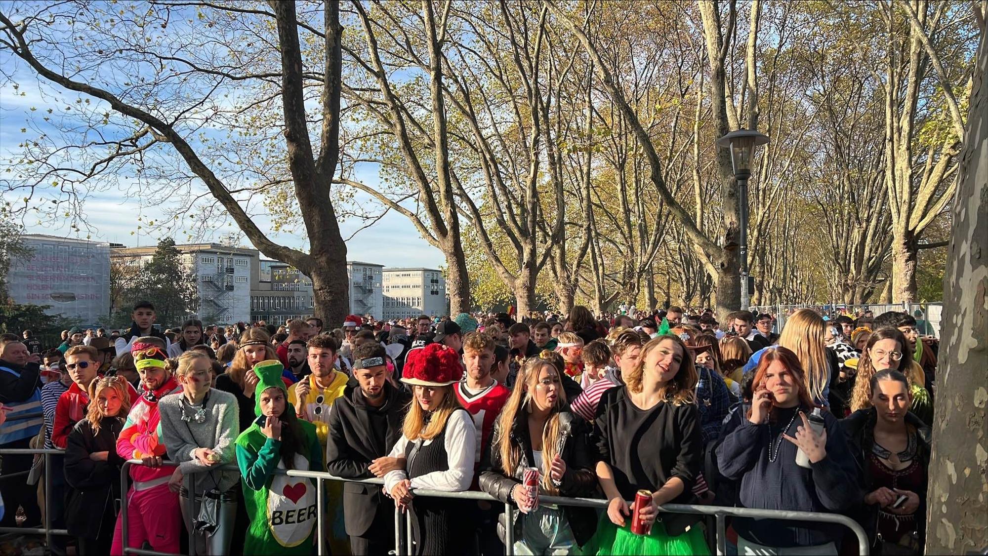 Viele verkleidete Personen stehen an einer Absperrung an der Uni-Mensa.