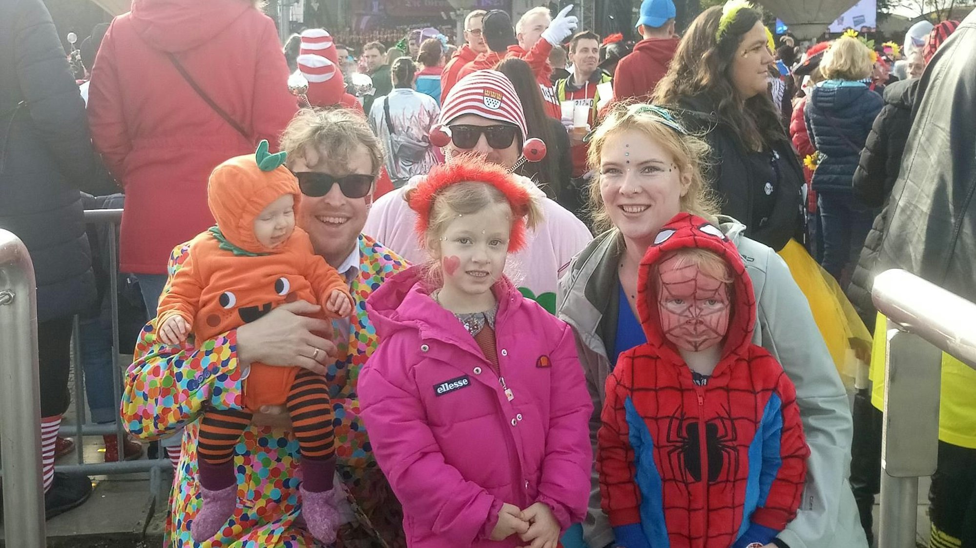 Mehrere Verkleidete mit ihren Kindern am Tanzbrunnen in Köln.