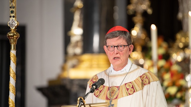 Rainer Maria Kardinal Woelki, Erzbischof von Köln, in festlichem Ornat und rotem Bischofskäppchen, predigt von einer goldverzierten hölzernen Kanzel in einem opulent ausgestatteten Kircheninnenraum.