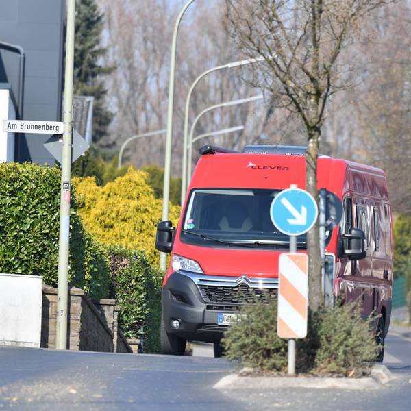 Ein roter Transporter fährt auf der Borromäusstraße hinter einer Fußgängerüberquerung.