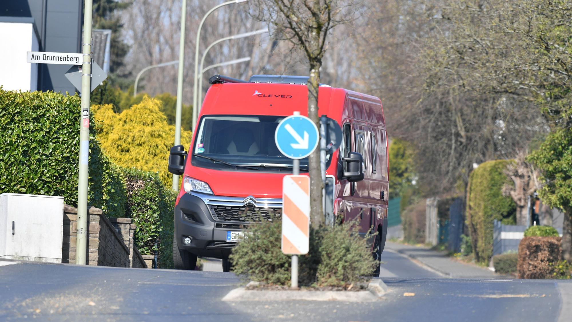 Ein roter Transporter fährt auf der Borromäusstraße hinter einer Fußgängerüberquerung.
