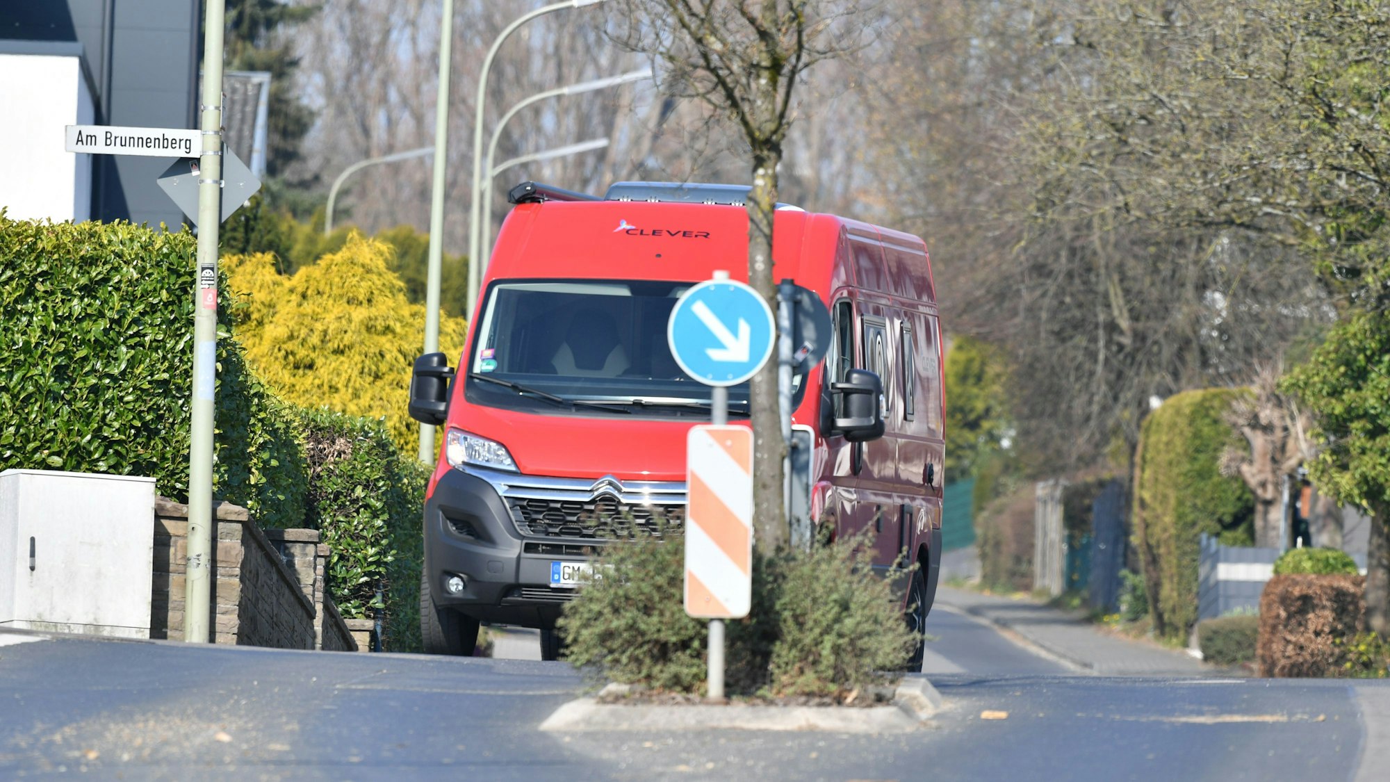 Ein roter Transporter fährt auf der Borromäusstraße hinter einer Fußgängerüberquerung.