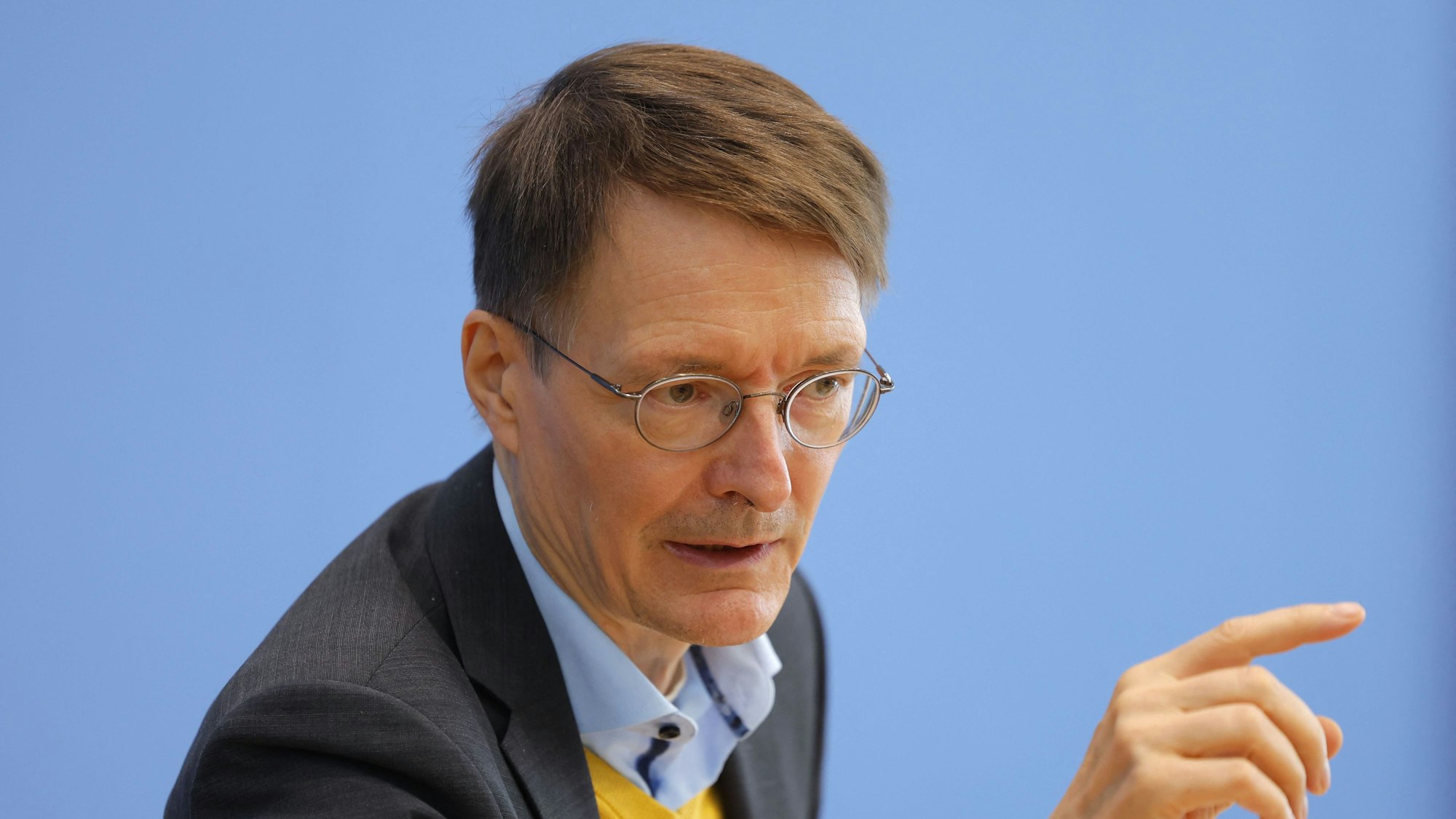 Karl Lauterbach zeigt während einer Pressekonferenz mit dem Finger in Richtung Pressevertreter.
