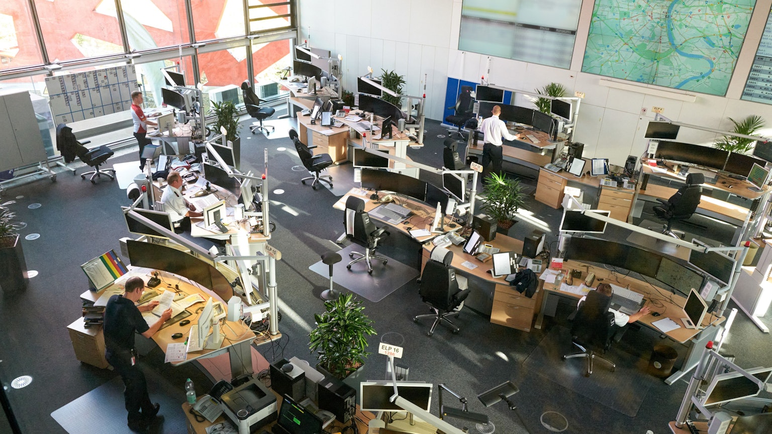 In der Leitstelle der Feuerwehr Köln sitzen und stehen Disponenten an ihren Arbeitsplätzen.